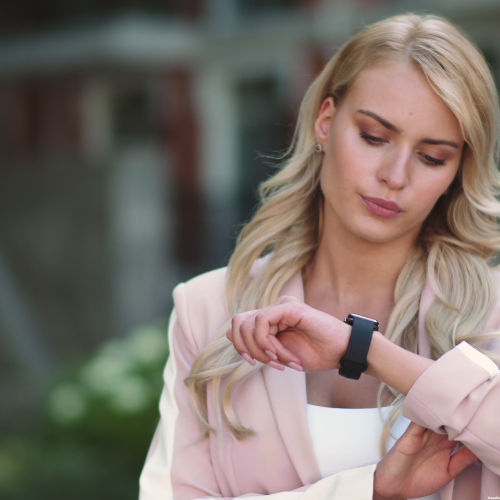 Femme regardant sa montre avec insistance car mauvaise gestion du planning